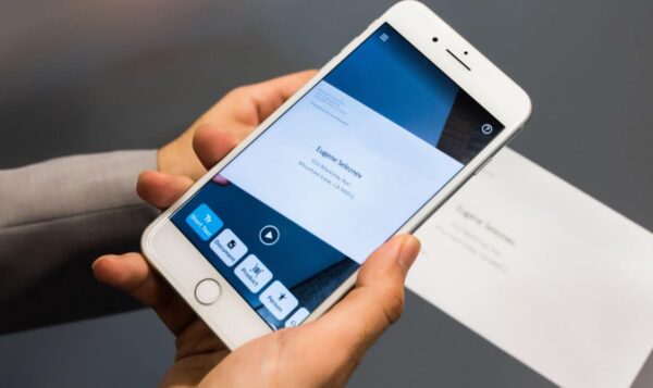 Image of a person holding a phone. An app on the phone is scanning a letter.